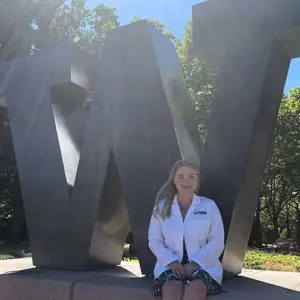 Athena Clemens sitting in front of big W