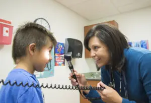 Dr. LeeAnna Muzquiz, WWAMI instructor, family medicine, performs a physical exam on a child patient at the Tribal Health Clinic in Polson, MT.