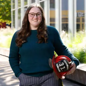 Kathryne Mitchell smiles while holding a firefighter helmet.