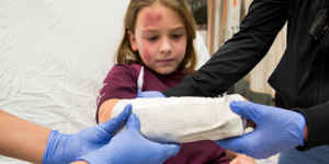 A pediatric burn patient gets their arm dressing changed.