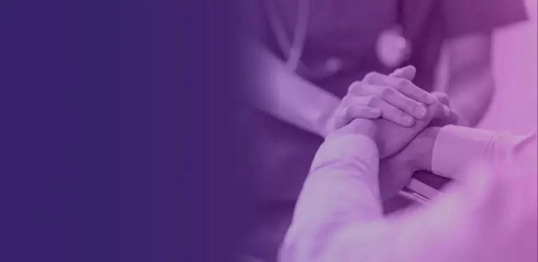 A doctor holding a patient's hands.
