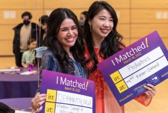 Two medical students pose with their "I Matched!" signs on Match Day 2023.