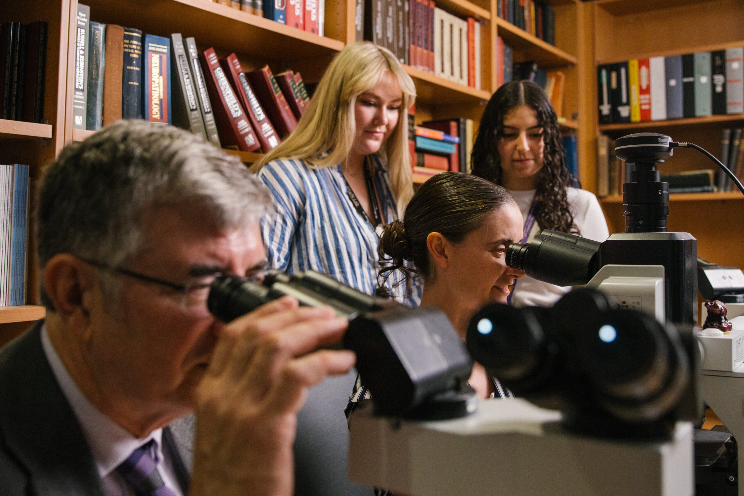 Dr. Grabowski and colleagues examining research materials through microscopes.