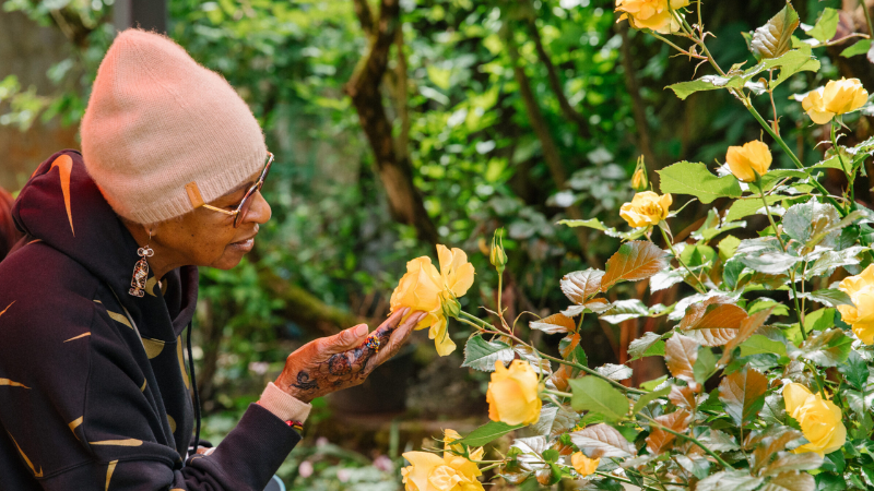 A Memory Hub visitor admires a yellow rose.