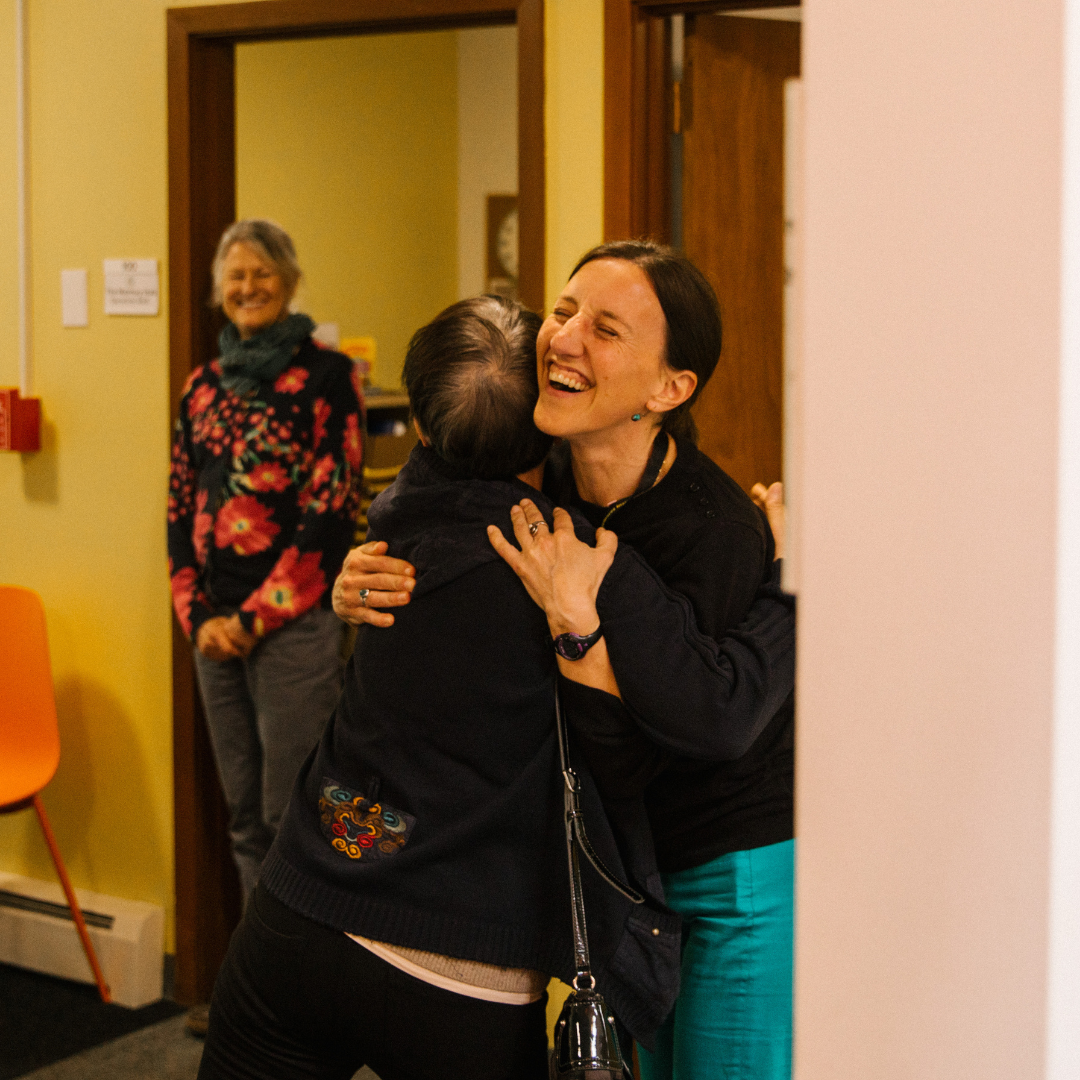 Marigrace Becker, director of the Memory Hub, hugs a visitor.