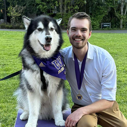 Patrick Hewes with Dr. Dubs (a husky dog wearing a purple UW Medicine bandana).